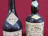 three bottles of wine are lined up on a red surface