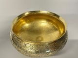 brass bowl with engraved design on it on a white surface