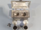 a silver box with two cups and a screw in it