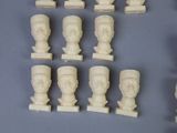 a lot of white marble busts on display on a table