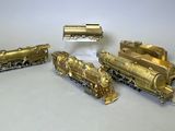 quatre types différents de trains en laiton posés sur une table