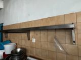 une étagère en métal au-dessus d'une cuisinière dans une cuisine
