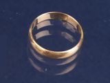 une bague en or posée sur une surface noire