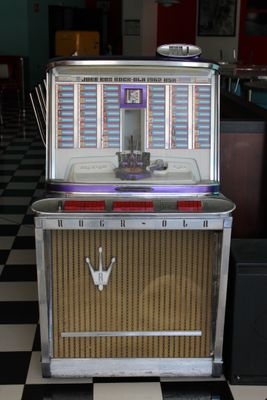 un juke-box posé sur un sol à carreaux noirs et blancs