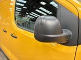 a close up of a yellow van with a side view mirror