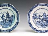 pair of blue and white plates with a landscape scene on them