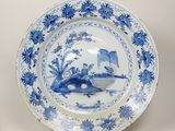 une assiette bleue et blanche représentant un bateau