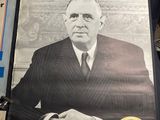 a poster of a man in a suit sitting on a chair