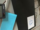 une photo d'un bureau encombré avec un ordinateur et un bloc-notes