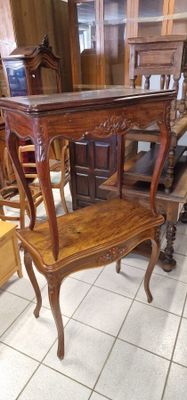une table surmontée d'une étagère, placée au milieu d'une pièce