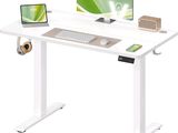 a computer desk with a monitor, keyboard, mouse and headphones