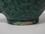 a close up of a green cup on a table