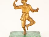 bronze figurine of a boy on a green marble base
