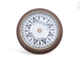 une horloge sur laquelle figure une boussole, sur fond blanc