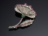 a close up of a brooch with a flower on a black surface