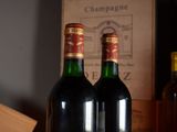 two bottles of wine sitting on a table next to a box of wine