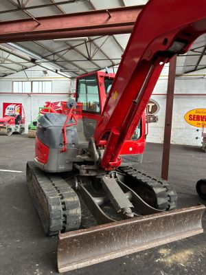 une pelleteuse rouge garée à l'intérieur d'un bâtiment