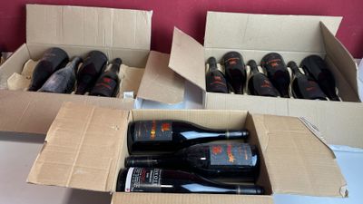 deux cartons contenant des bouteilles de vin posés sur une table