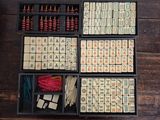 an overhead view of a wooden box filled with assorted pieces of domino board