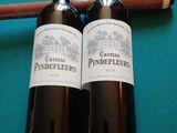 deux bouteilles de vin et un cigare posés sur une table de billard