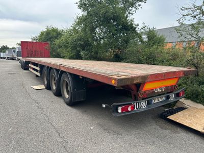 un camion à plateau garé sur le bord de la route