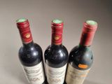 three bottles of wine are lined up on a table