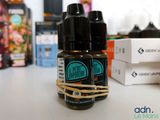 three bottles of e - liquid sitting on a table next to a box of e - liquids