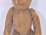 un ours en peluche marron assis sur une surface blanche