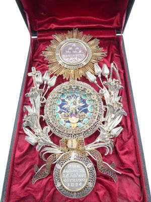 une boîte ouverte contenant une médaille et sur laquelle est posée une médaille