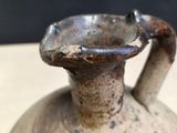a very old looking vase sitting on a table