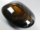 une photo d'un objet en verre brun posé sur une surface blanche