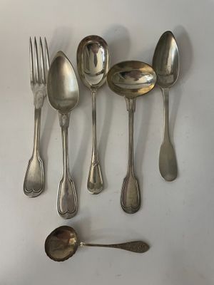 six spoons and a fork are arranged in a row on a white surface
