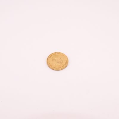 une petite pièce d'or sur un fond blanc