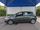 a small green car parked under a blue awning