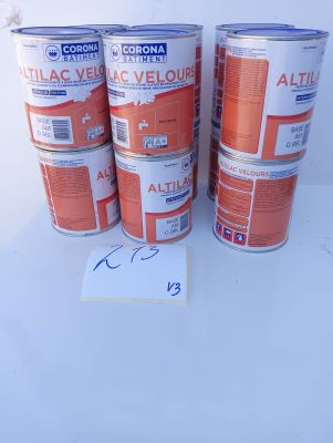 four cans of orange paint sitting on top of a white table