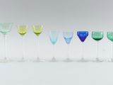 several different colored wine glasses are lined up in a row