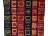 six livres rouges et noirs alignés sur une surface blanche