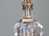 a glass bottle with a gold and silver decoration on it