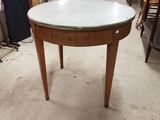 une table ronde avec un plateau en verre au milieu d'une pièce