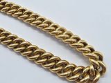 a close up of a gold chain on a white surface