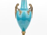a blue vase that is sitting on a gold stand