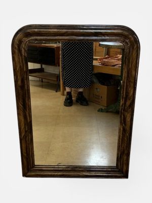 une femme debout devant un miroir dans une pièce