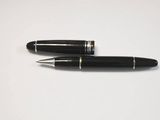 two black pens sitting next to each other on a white surface