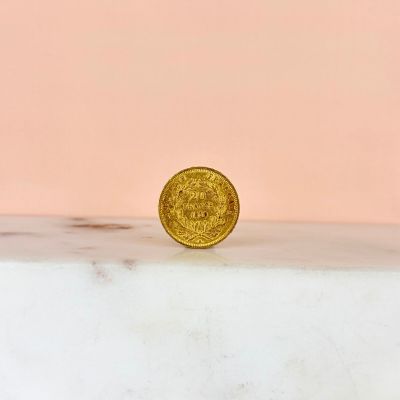 a gold coin sitting on top of a marble counter top