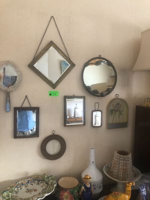 de nombreux miroirs de toutes sortes accrochés au mur au-dessus d'une table