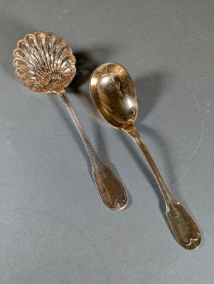 two spoons and a spoon rest on a gray surface