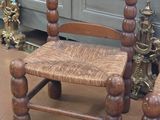 a wooden chair that is sitting in front of a cabinet