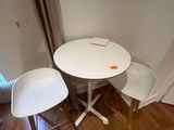 a small table and two chairs in the corner of a room