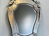 a mirror hanging on the wall with a bird on it