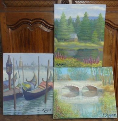 trois tableaux représentant des bateaux sont posés sur une table en bois à côté d'une chaise